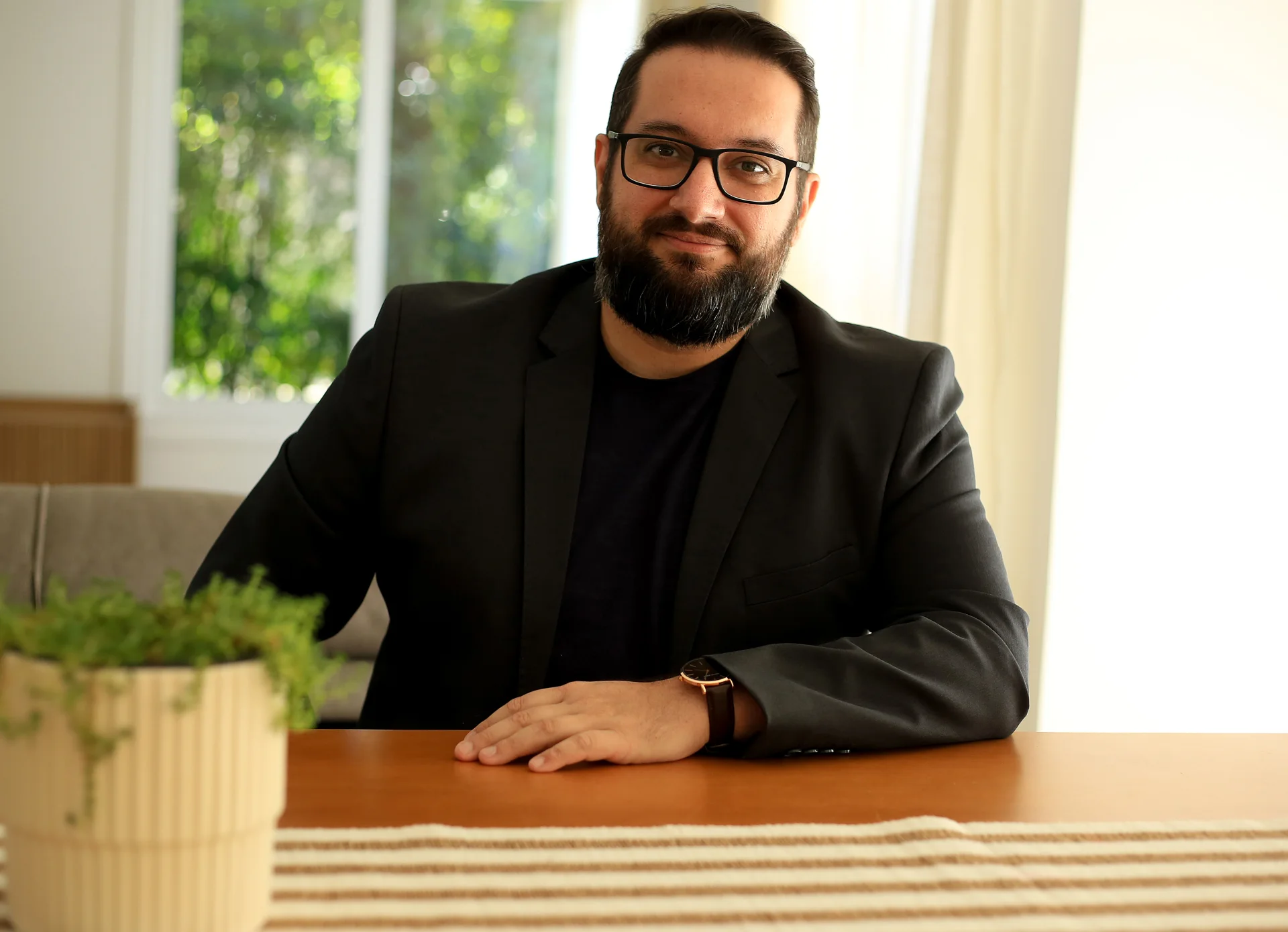 Athos Alves de Souza, mentor em CX e Zendesk, sentado à mesa